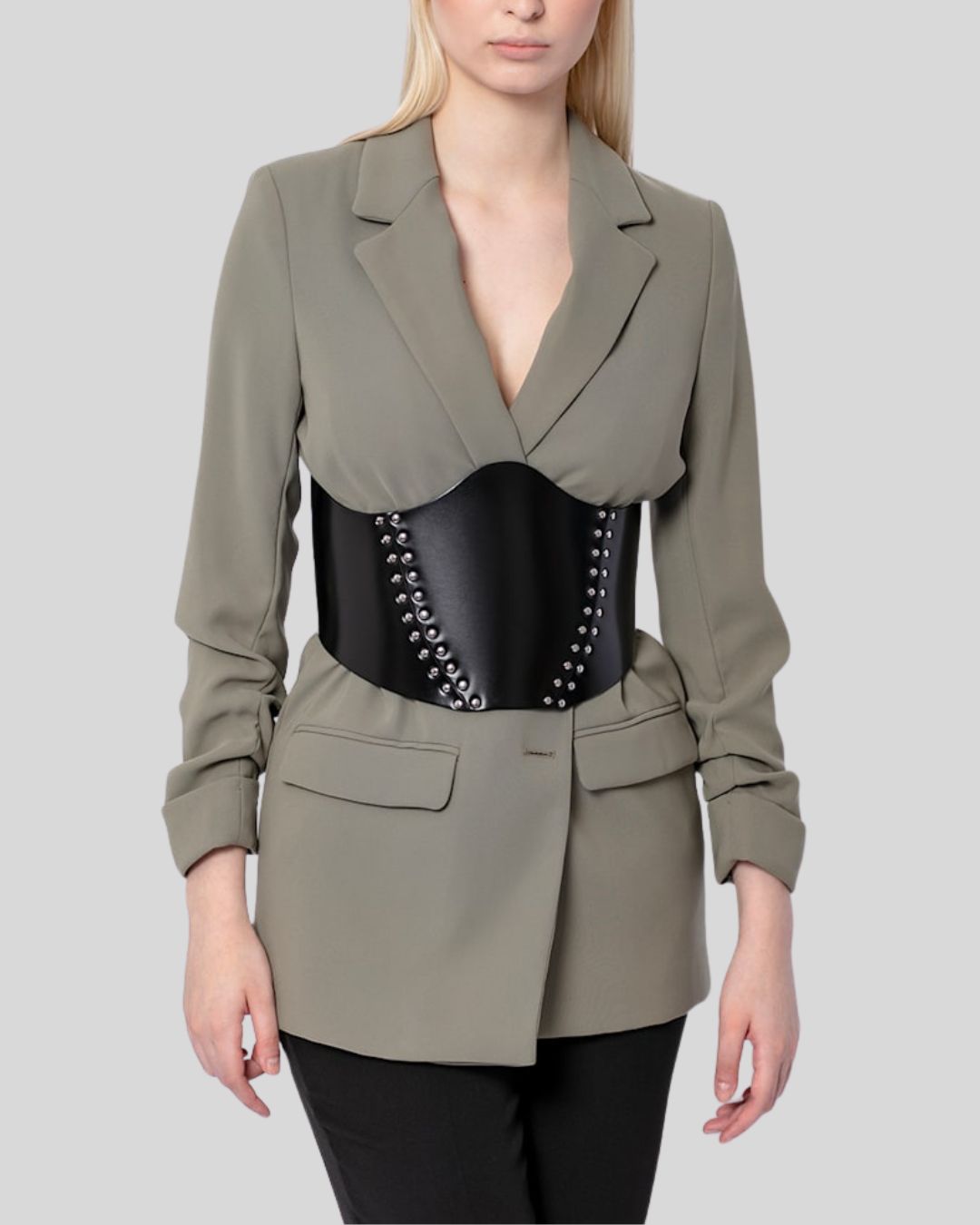 Front view of a black leather corset belt for women worn over a green blazer