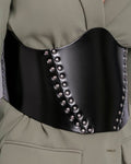 Close-up of silver rivets and gloss finish on black leather corset belt
