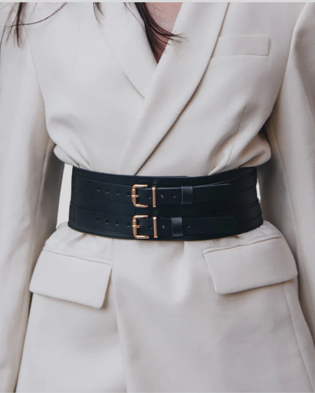 full body view of woman in strapless jumpsuit with black waist cincher belt