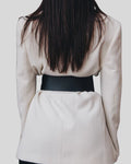 back view of wide black leather belt over cream blazer