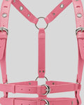 close-up of pink leather harness center strap and silver O-ring with buckle details
