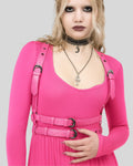 model wearing pink leather body harness with double waist straps over pink dress