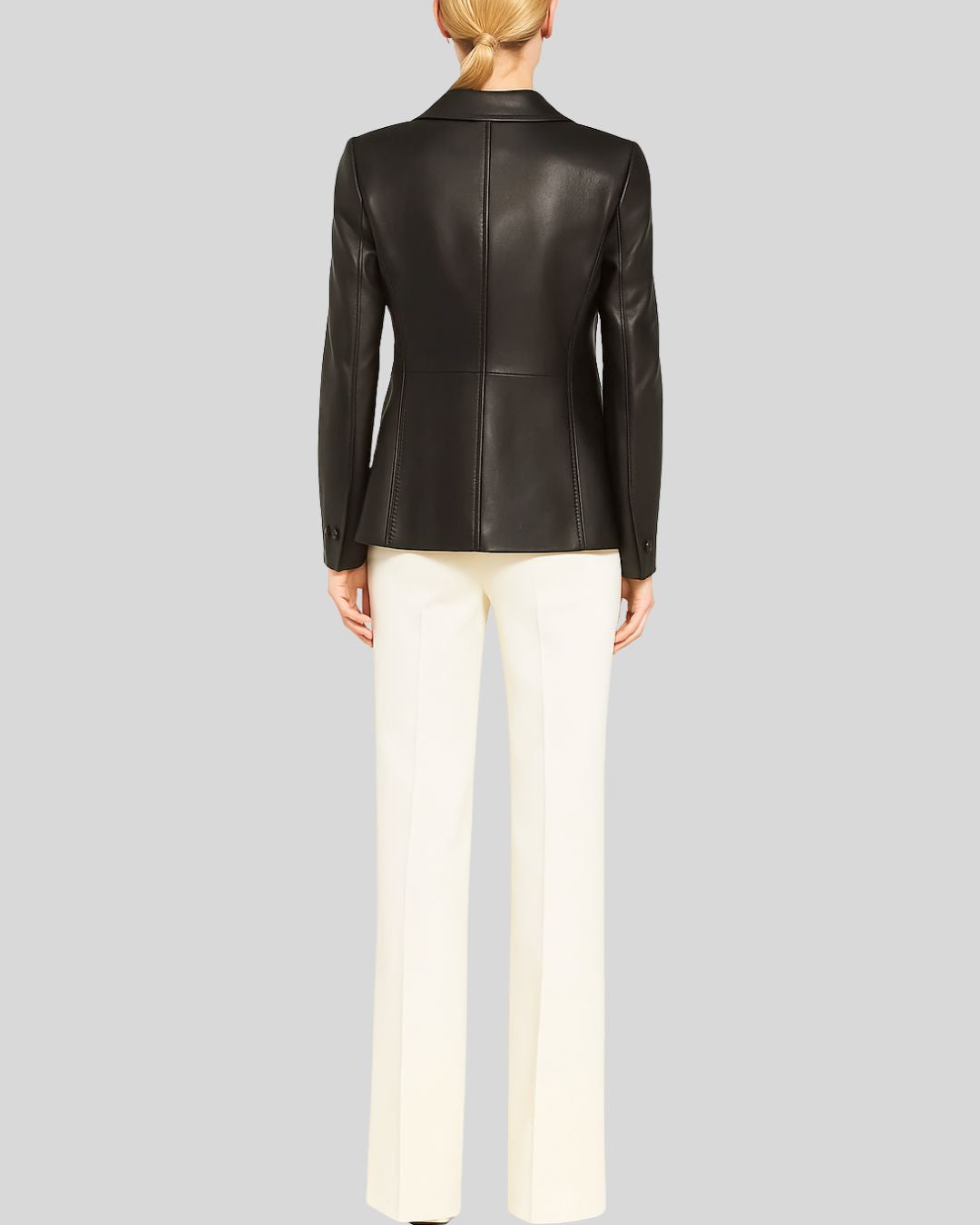 Woman wearing black leather blazer jacket with Peter Pan collar and ivory trousers