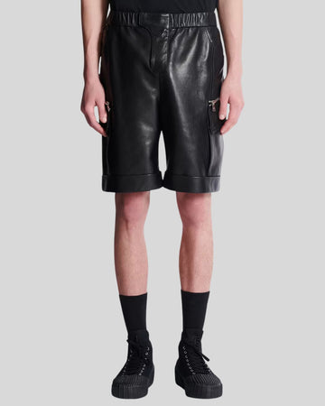 Men wearing black leather cargo shorts with zipper pockets and rolled hems
