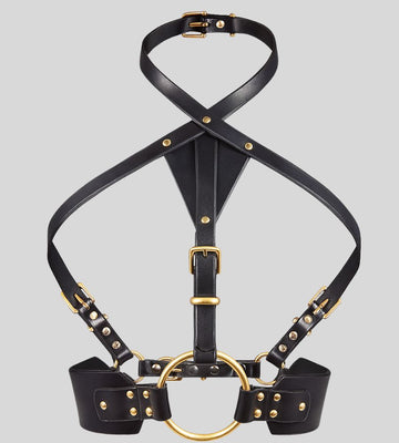 black leather harness with gold ring laid flat