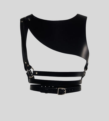  Flat lay of black asymmetrical leather body harness with silver hardware