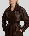 Close-up of wide lapel and belted cuff on brown leather trench coat for women