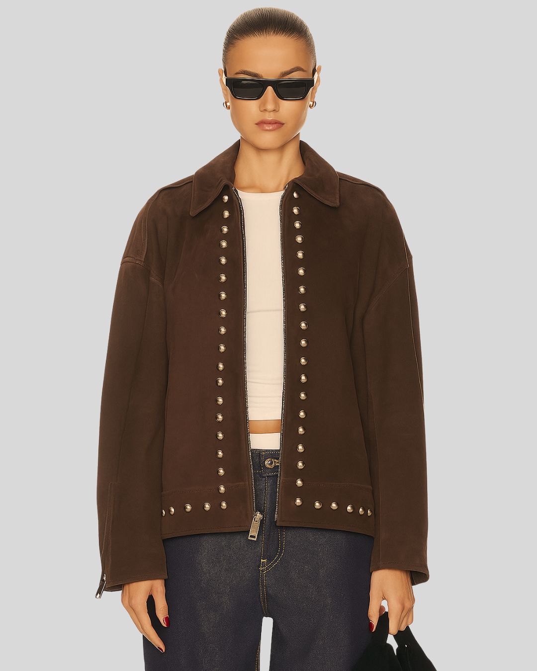Women wearing a brown jacket with studded details on a plain background