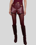 Front view of women’s burgundy leather shorts with gold buttons