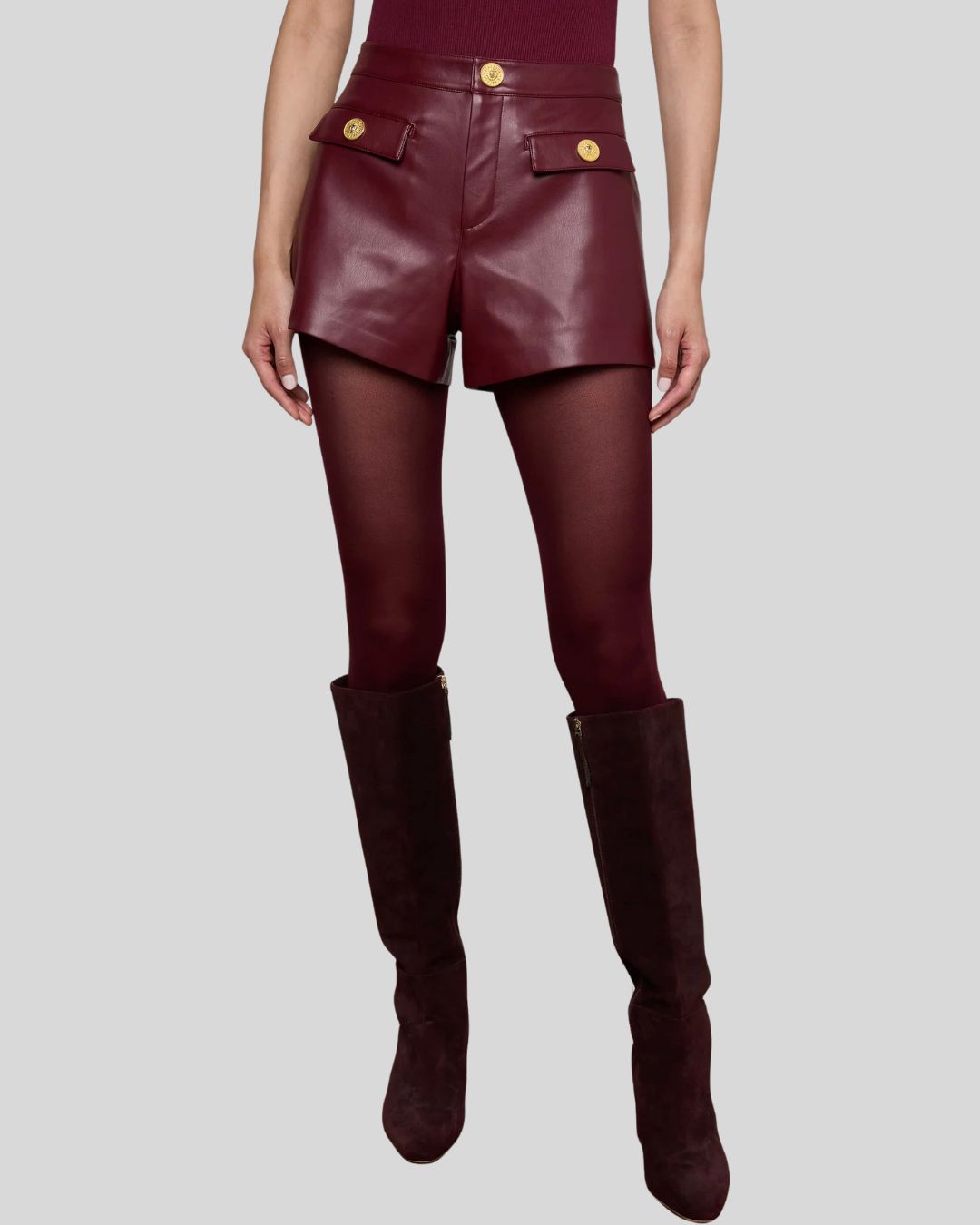 Front view of women’s burgundy leather shorts with gold buttons