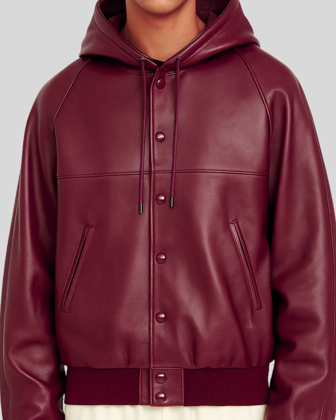 Detail of snap button closure and pockets on burgundy leather bomber