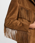 Close-up of sleeve fringe and soft suede texture of a tan jacket.
