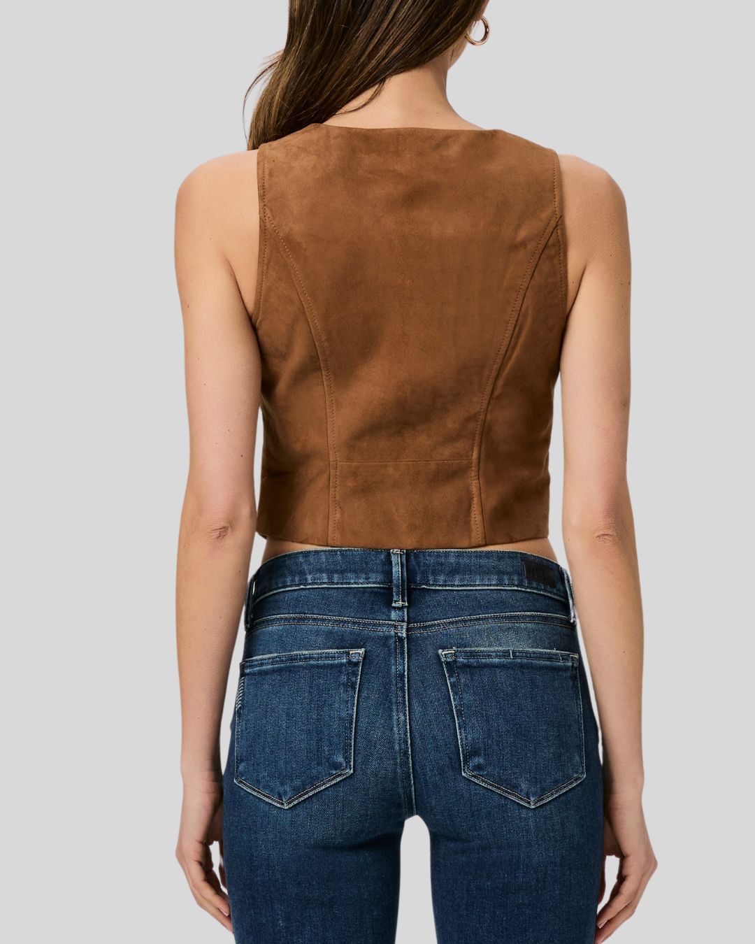 Woman wearing a brown suede leather vest with front button closure
