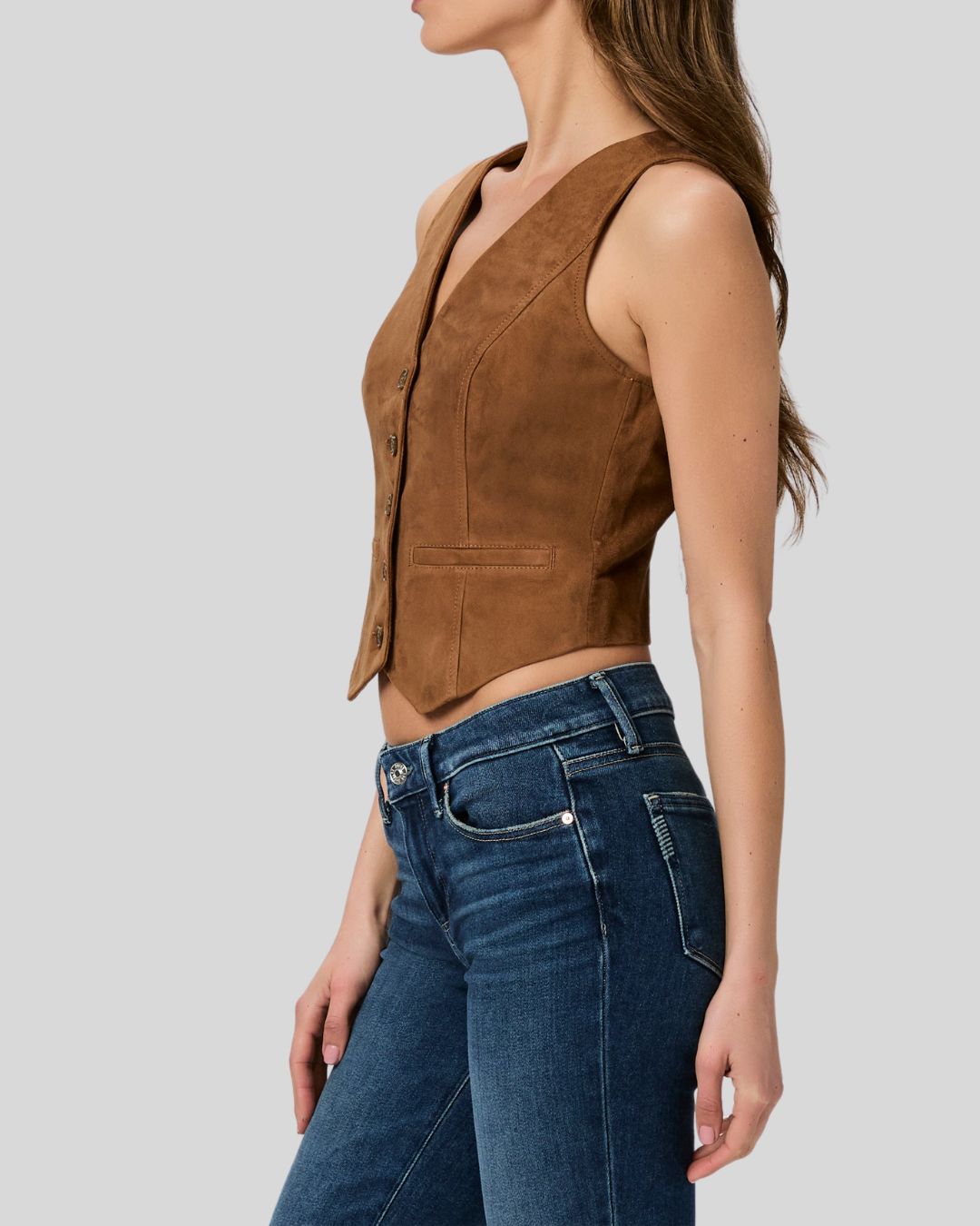 Woman wearing a brown suede leather vest with front button closure
