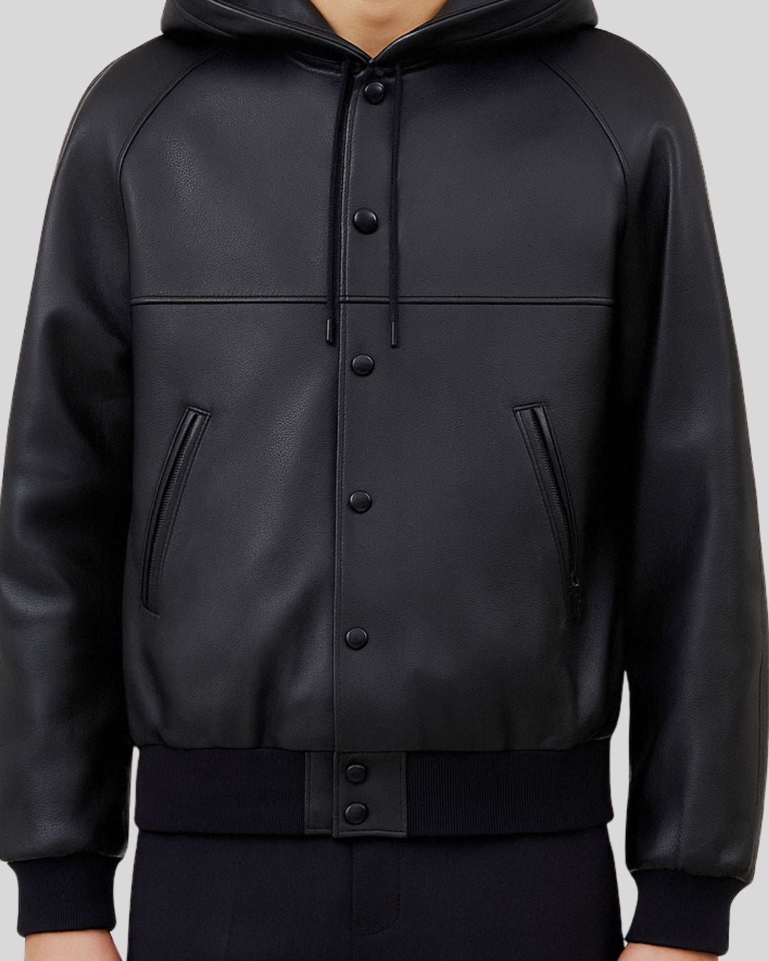 Zoomed-in detail of button closure and pockets on black leather bomber