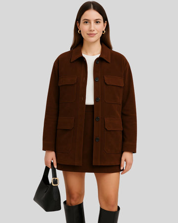  Full body view of a woman wearing a dark brown suede field jacket with a mini skirt and tall boots
