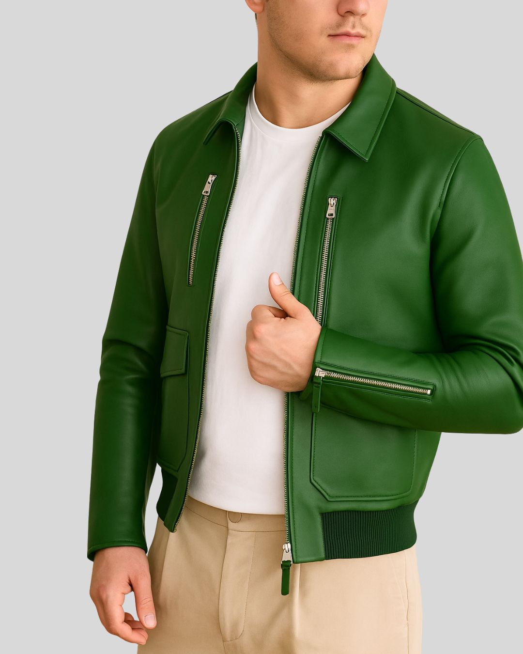 Close-up of green lambskin bomber jacket’s silver zippers and waist pocket.