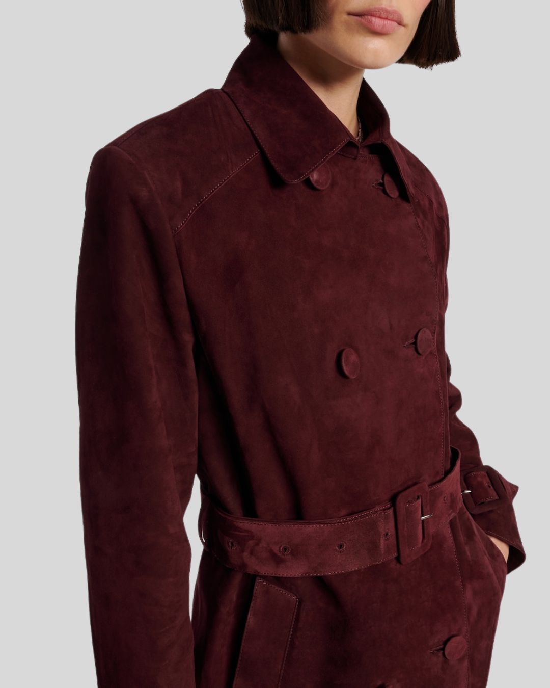 Close-up of burgundy suede trench coat buttons and lapel
