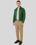 Man in full outfit wearing green bomber jacket, beige trousers, and black sneakers.