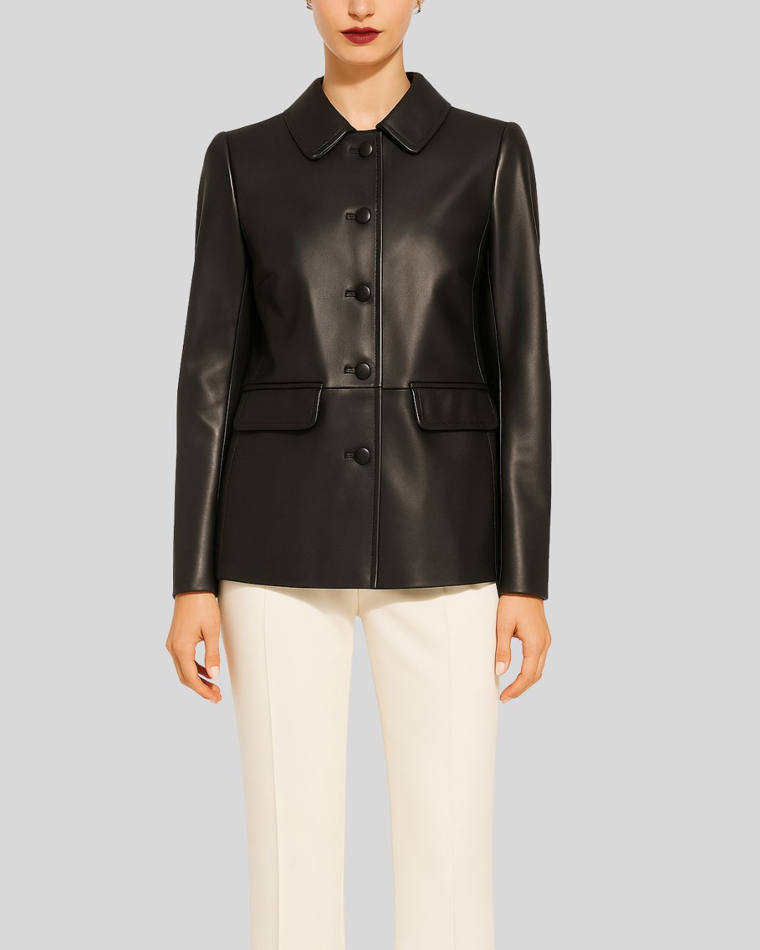 Woman wearing black leather blazer jacket with Peter Pan collar and ivory trousers