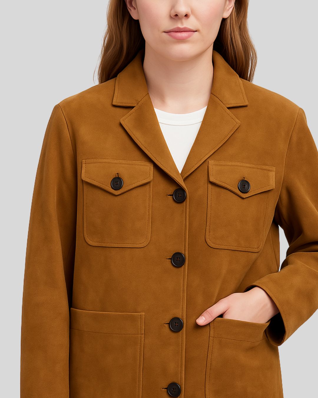  Close-up of buttoned chest pockets on camel suede jacket