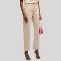  Woman wearing beige straight-leg pants holding pink purse