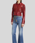 Side angled view of red fringe leather jacket paired with jeans
