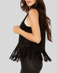  Side view of woman wearing black suede vest with studs and fringe
