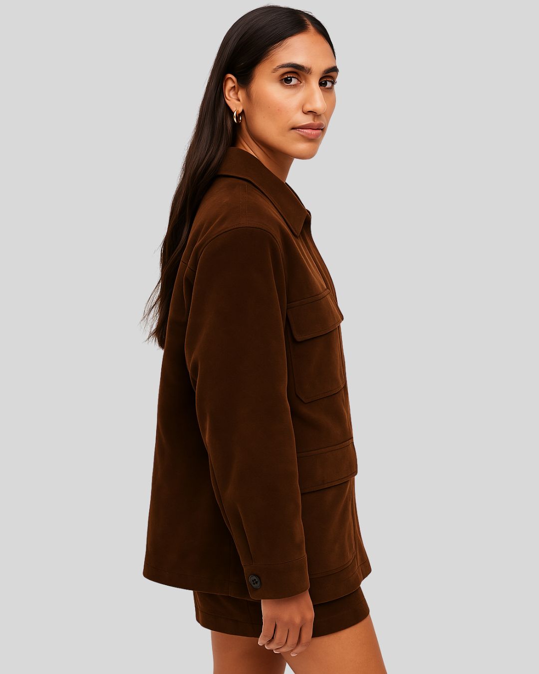 Side view of a women's dark brown suede utility jacket worn with matching shorts
