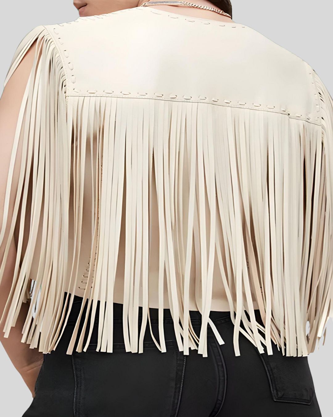 Model wearing cream leather fringe vest with white top and black pants
