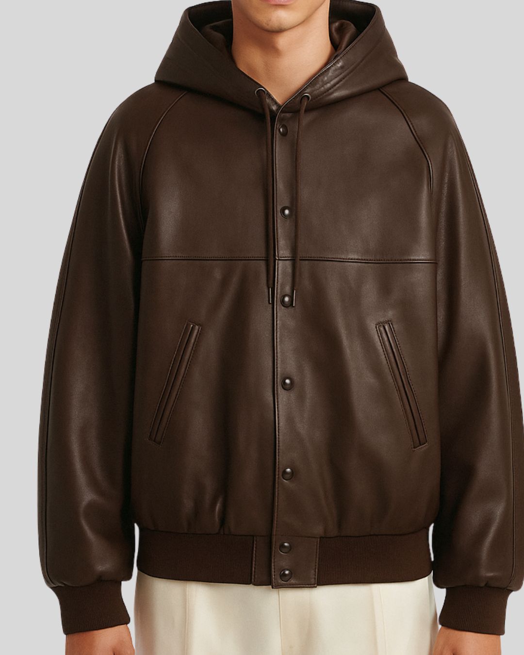 Close-up of snap closure and pockets on brown leather varsity jacket