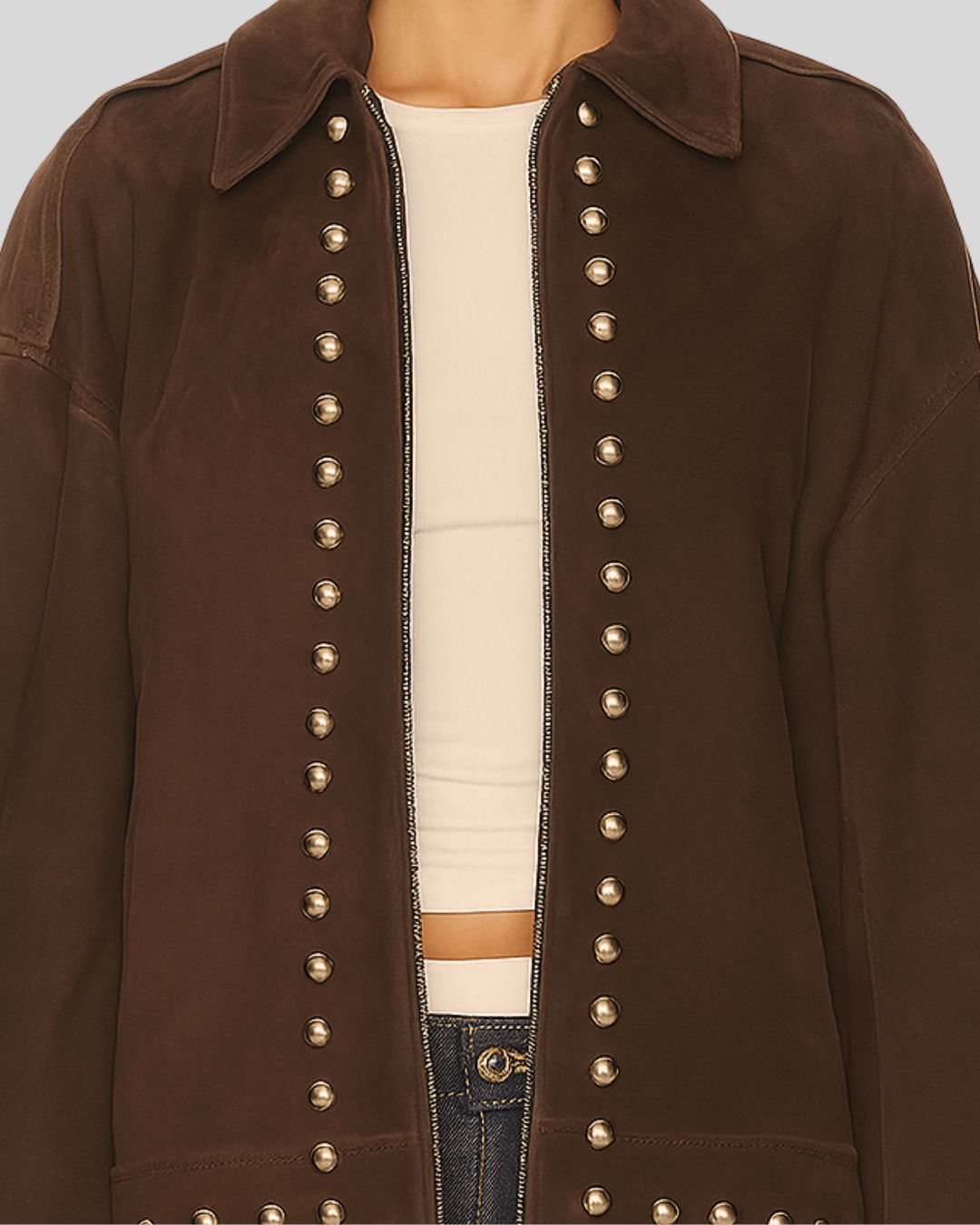 Close up view brown suede jacket with studded details on a neutral background